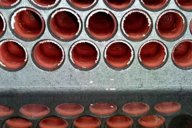 Cleaning systems for shell and tube heat exchangers